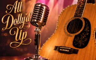 “All Dolly’d Up” graphic with a vintage microphone, acoustic guitar, and warm stage lights in a country-inspired concert setting.